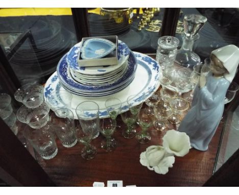 A quantity of glassware to include sherry glasses and similar, a decanter, a quantity of blue and white plates, a Nao figurin