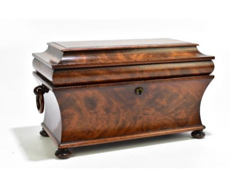 A 19th century mahogany sarcophagus form tea caddy with twin ring handles, on four bun feet, the three section interior compl