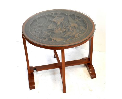 A reproduction Chinese carved and stained teak circular topped folding coffee table, height 55cm, diameter 61cm.