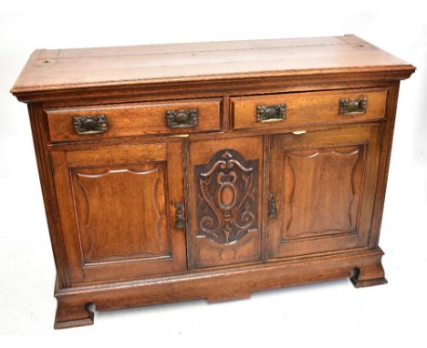 An Arts &amp; Crafts oak dresser base/sideboard with carved detail and two short drawers over two cupboard doors to front, he