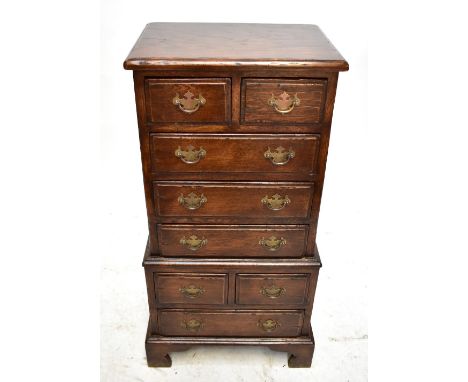 A reproduction oak chest of eight drawers of small proportions, raised on bracket feet, height 90cm, width 44cm, depth 31cm.A