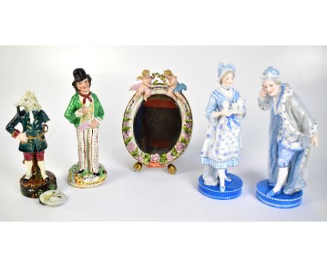 A pair of late 19th century Continental blue and white hard paste porcelain figures of a gentleman and a lady holding a tea s