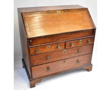 A George III oak bureau, the fall front with fitted interior and sliding well above two short over two long drawers, on brack