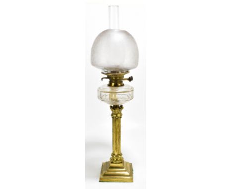 A 19th century oil lamp with foliate etched shade above clear reservoir, with clear glass chimney, on column to stepped squar