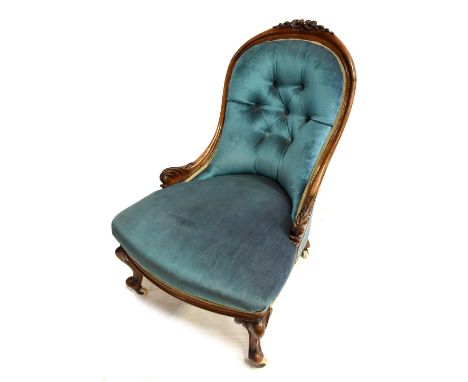 A Victorian carved walnut framed spoon back nursing chair raised on cabriole supports terminating on ceramic castors.Addition