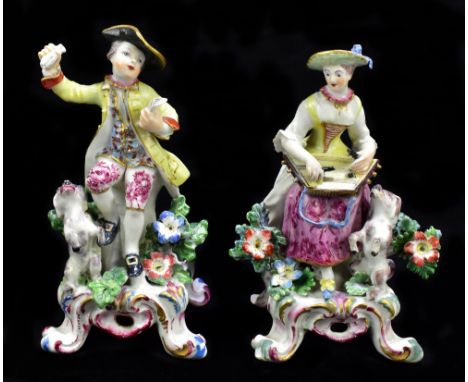 DERBY; a pair of 18th century figures, she with dancing dog by her feet and playing a musical instrument, he similarly with a