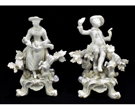 DERBY; a pair of 18th century blanc-de-chine figures, the female playing the hurdy gurdy with a dancing dog by her feet, the 