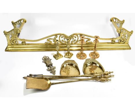 An Art Nouveau brass fender with scrolled detail, width 135cm, depth 36.3cm, two brass trays, door knocker, two pairs of cand