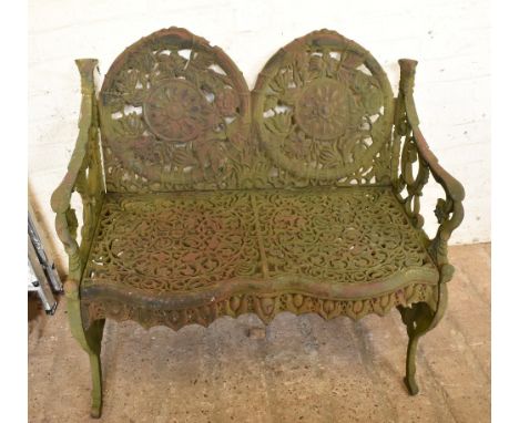 A green painted cast iron two seater garden bench with cast floral decoration and mask head finials, stamped 'Autumn' to the 