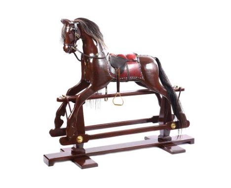 VINTAGE MAHOGANY ROCKING HORSE WITH OX BLOOD LEATHER SADDLE WITH BRASS STUDS.HEIGHT: 50 INCHES.WIDTH: 60 INCHES.DEPTH: 21 INC