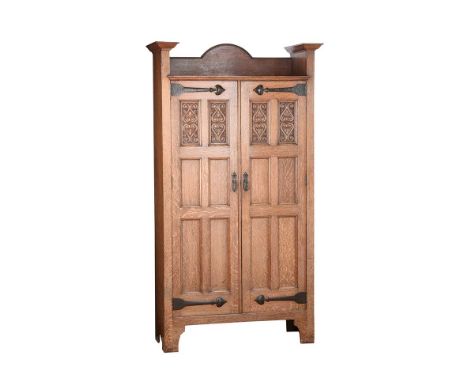 OAK ARTS & CRAFTS HALL CUPBOARD.DESIGNED BY SHAPLAND & PETTER.RAISED TOP OVER PANELLED DOORS WITH PATENTED  COPPER HINGE BRAC