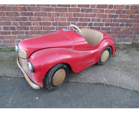 AN ORIGINAL AUSTIN J40 PEDAL CAR, finished in red with chrome fixtures and fittings, complete with headlights, engine interio