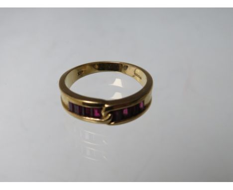 AN 18CT GOLD GEMSET RING, of simple crossover design  with 8 baguette cut channel set ruby type gemstones, ring size Q - Q½, 