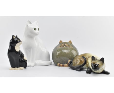 A collection of four vintage 20th century ceramic pottery cat figurines. The lot comprising a seated white cat with glass eye