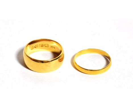 An 18 carat gold band ring, finger size K; and a 22 carat gold band ring, finger size K1/2.  18 carat gold band ring - 6.6 gr