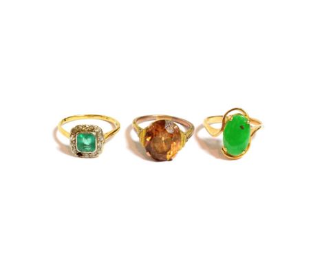 An emerald and diamond cluster ring, stamped '18CT', finger size M1/2 (one stone deficient); a jade ring, unmarked, finger si