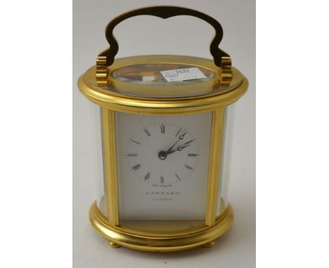 A "Garrard" of London, oval brass cased carriage clock, white enamel dial with Roman numerals, 11cm high