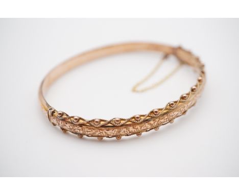 A Victorian 9ct gold hinged bangle, the face being bright-cut engraved, pelleted and wirework decorated, 7.7g