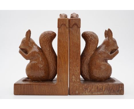 A pair of Robert "Mouseman" Thompson of Kilburn carved oak book ends modelled as squirrels sat eating nuts, 20 cm