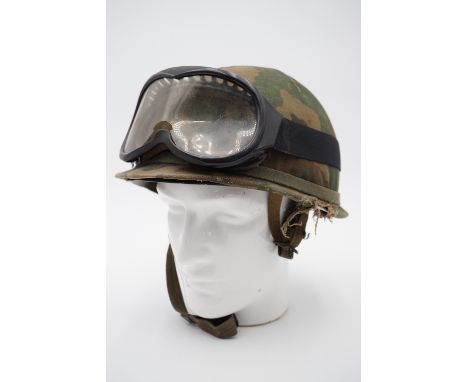 A Falklands War Argentinian special forces helmet, cover and goggles, the cover bearing the inscription "The owner of this he