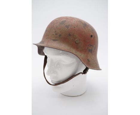 A German Model 1942 helmet with camouflage over-paint