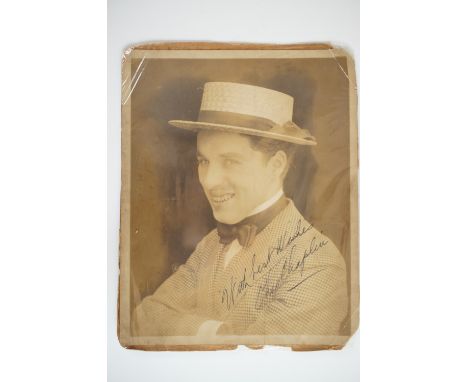 [ Autograph / Charlie Chaplin ] A signed portrait photograph of the comic actor and film maker Charles Chaplin, Chaplin weari