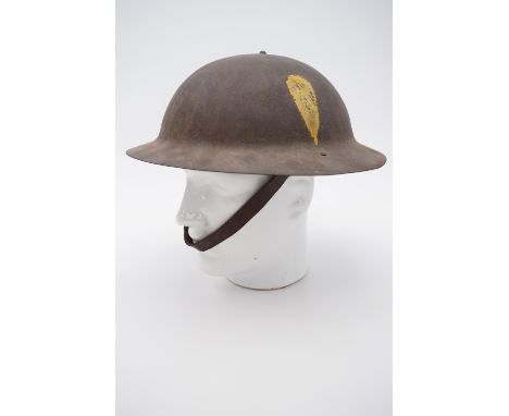 A Great War British Army Brodie pattern helmet, bearing a painted yellow hackle device (Lancashire Fusiliers) to its rimless 