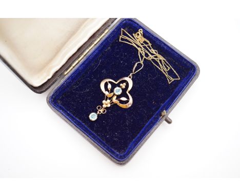 An Art Nouveau yellow-metal and aquamarine pendant necklace, in an openwork design, incorporating a round-cut claw set aquama