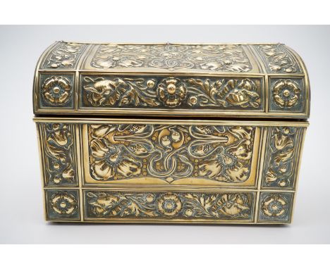 An early 20th Century Art Nouveau brass stationery box, relief-decorated overall in patterns of poppies, the hinged lid openi