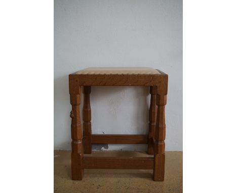 A Robert "Mouseman" Thompson of Kilburn carved oak dressing table stool, having a hide-upholstered seat and octagonal-section