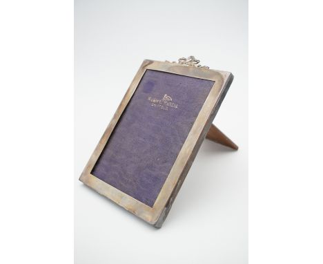 A 1920s silver photograph frame, with ribbon bow surmount, and oak easel back, Walker and Hall, Sheffield, 1925, 17 x 13 cm t