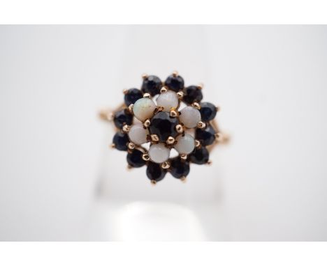 A vintage sapphire and opal flower head cluster cocktail ring, having a central sapphire of approximately .24ct, M, 3.3g