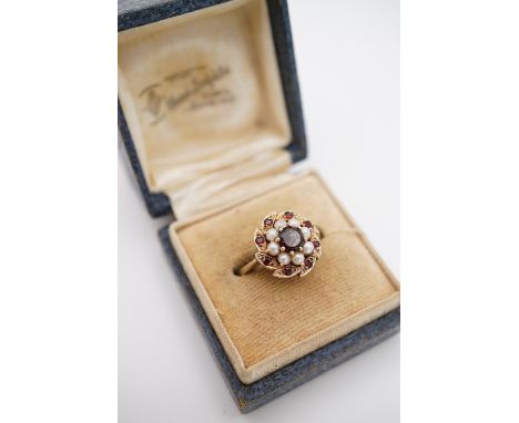 A vintage 9ct gold, garnet and pearl flower-head cluster dress ring, with central garnet of approximately .60ct, framed by pe