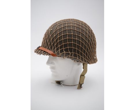 A Second World War US army M1 helmet, having fixed chin strap bales and frontally-welded shell rim