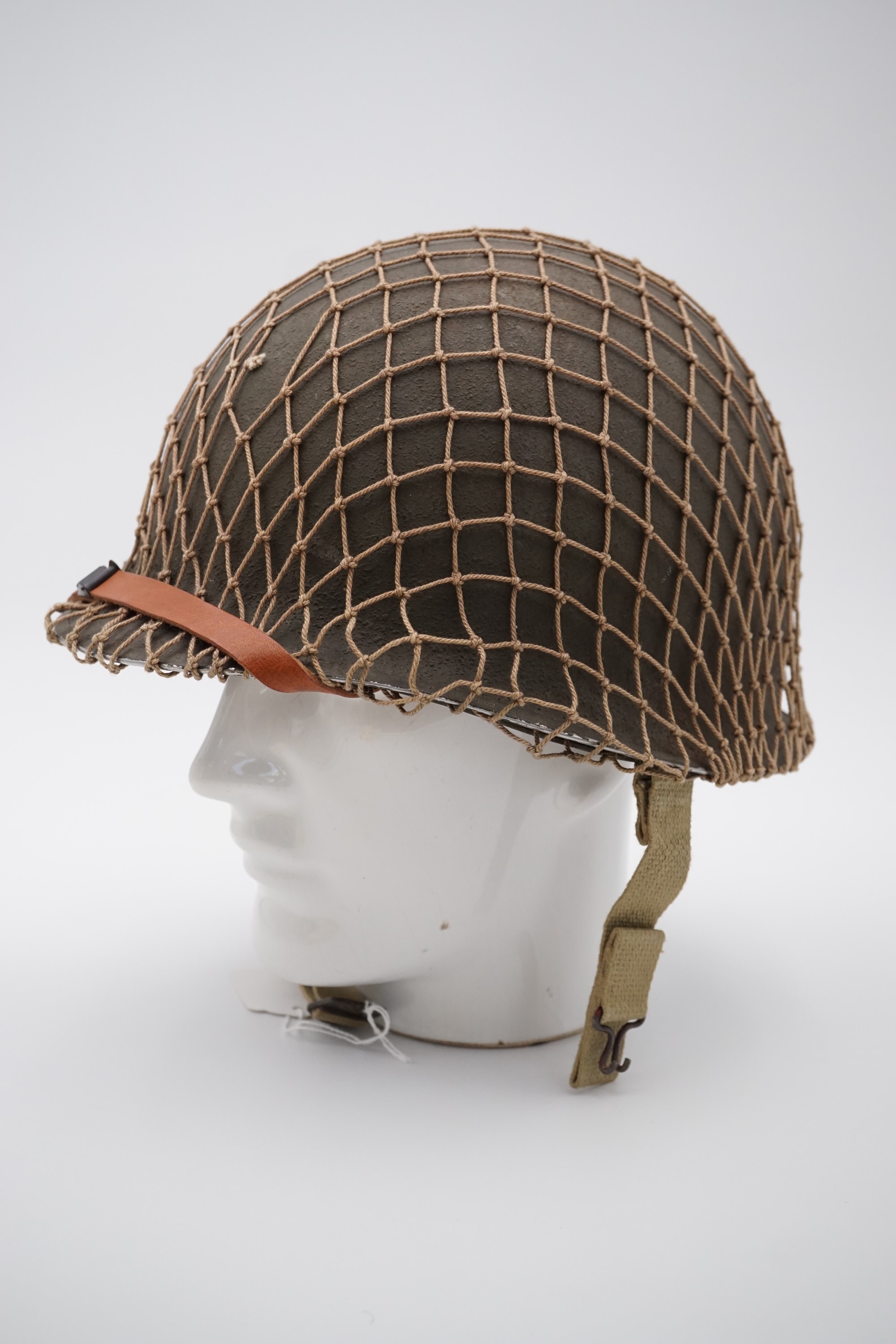 A Second World War US army M1 helmet, having fixed chin strap bales and ...