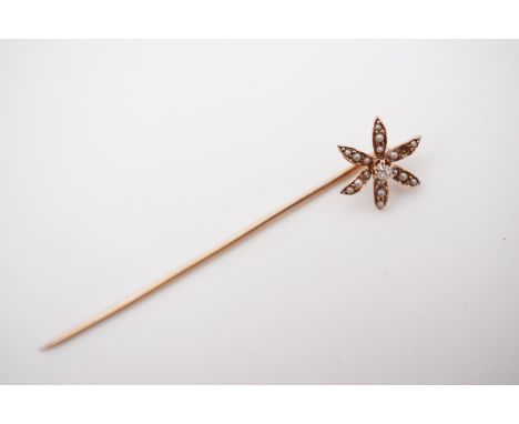 A Belle Epoque diamond and pearl stick pin, the terminal in the form of a flower, centrally set with an old cut diamond of ap