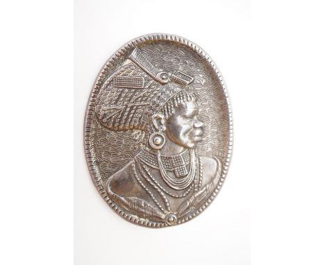 A vintage white metal brooch, bearing the reposse moulded profile portrait of a South African lady, stamped 'Canada, S. Afric