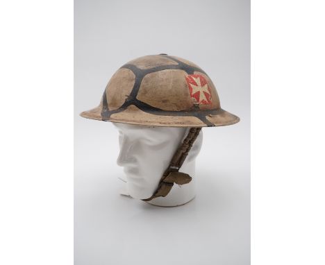 A Second World War British army helmet with Malta pattern camouflage and badge