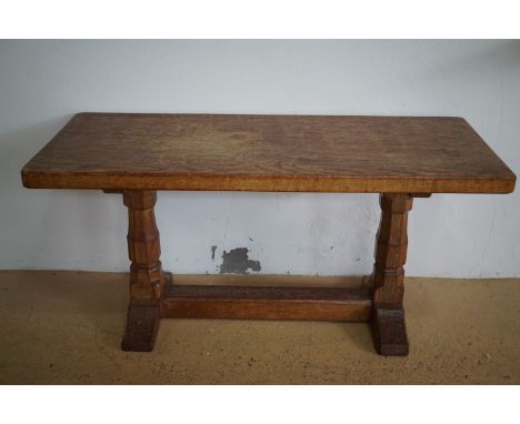 A Robert "Mouseman" Thompson of Kilburn carved oak coffee table, having a rectangular top raised on octagonal-section baluste