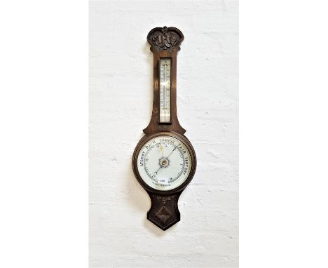 OAK CASED ANEROID BAROMETERwith a floral carving above the thermometer, with a circular dial below, 79cm high 