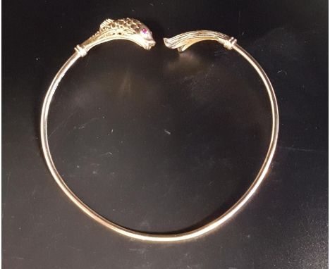 NINE CARAT GOLD FISH DECORATED BANGLEthe finials with detailed fish body and tail respectively, with ruby set eyes, approxima