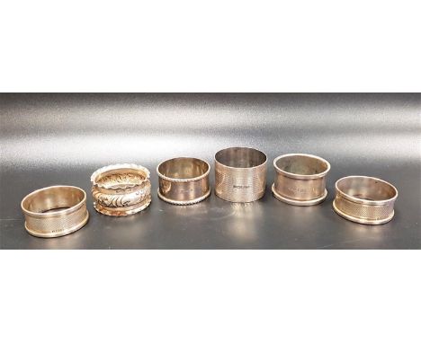 SIX SILVER NAPKIN RINGSof various designs, comprising a pair with engine turned decoration and and blank rectangular panels f