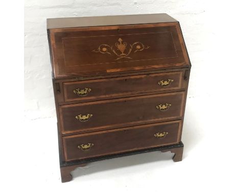 EDWARDIAN MAHOGANY AND INLAID BUREAUthe inset fall flap opening to reveal a fitted interior, above three long drawers and sta
