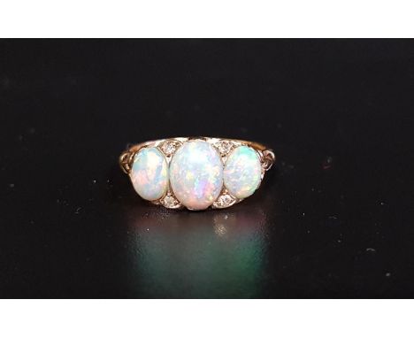 PRETTY OPAL AND DIAMOND RINGthe three graduated oval cabochon opals with small diamonds between, on eighteen carat gold shank