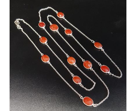 CARNELIAN SET SILVER NECKLACEthe twelve faceted carnelians separated by silver chain sections, 94cm long 