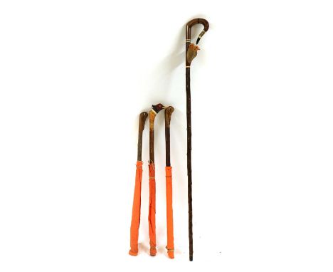 A modern carved walking stick and three beater's flag sticks,the first with a pair of game birds, the second with a pheasant,