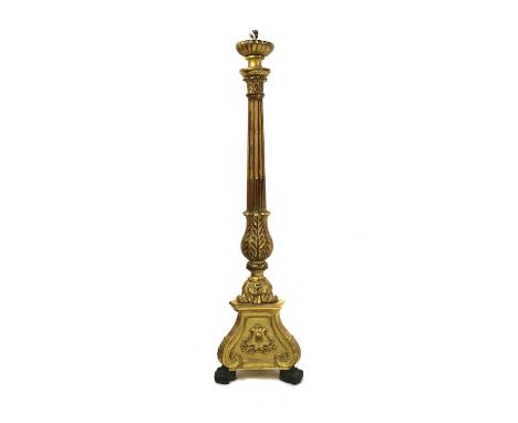 A carved and giltwood standard lamp,20th century, with a carved column, raised on a triform base and carved claw feet,154cm h