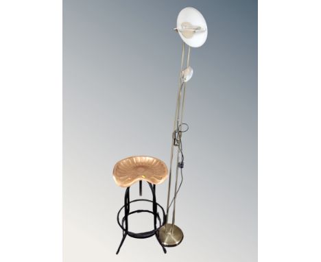 A contemporary tractor style seat bar stool together with a floor standing reading lamp 