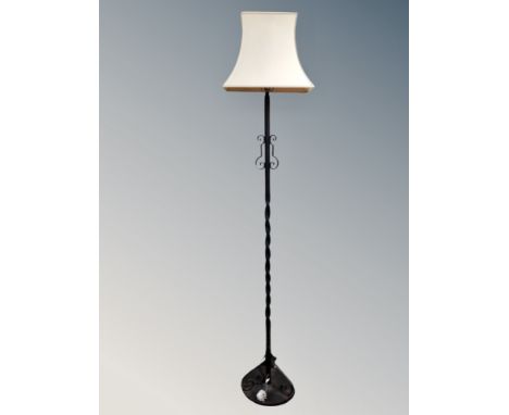 A wrought iron standard lamp with shade 