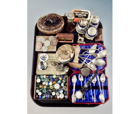 A tray of collectables, glass marbles, NUFC badges, rock sample, coins, cruet set, brass terrier knocker, plated cutlery etc 